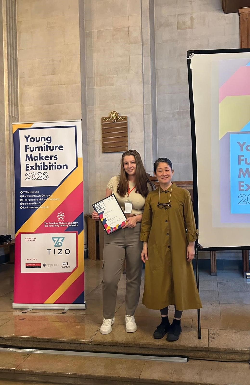 At the Young Furniture Makers Exhibition 2023, 2 Crofts & Assinder's colleagues pose for a photograph